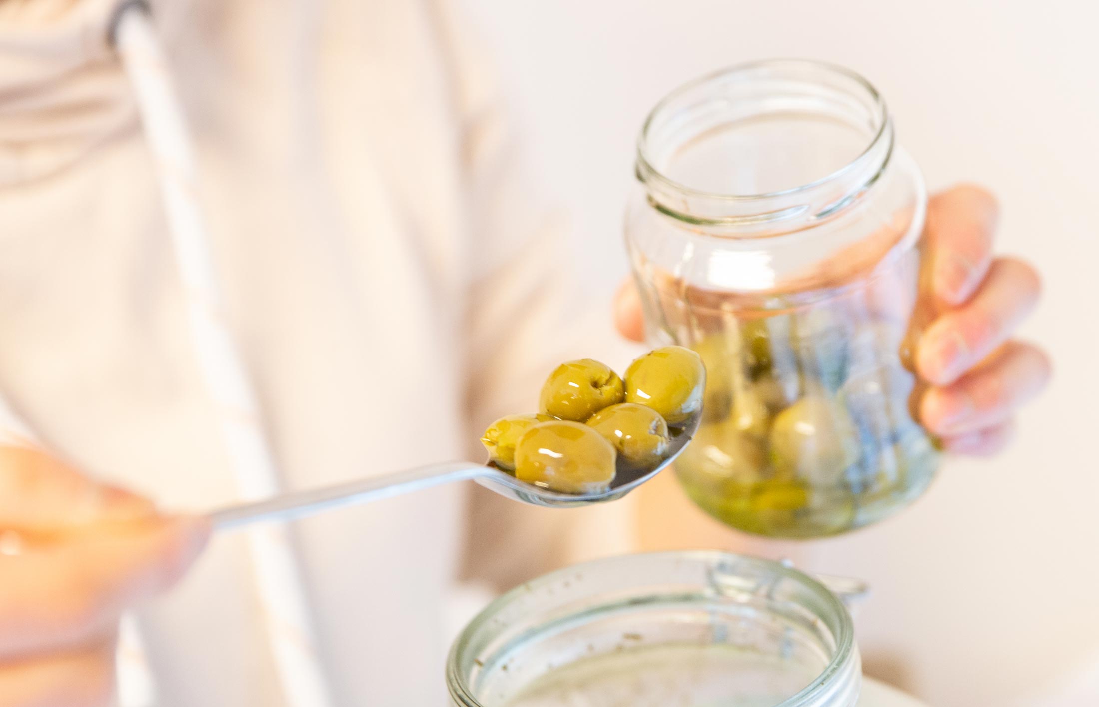 Oliven aus Glasbehälter entnehmen